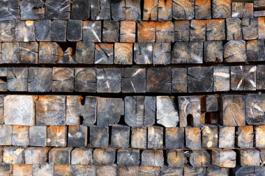 Doğal dokusu olan istiflenmiş tahta kirişler. Kırsal bir arka plan. Kare ahşap parmaklıklar duvar kağıdı