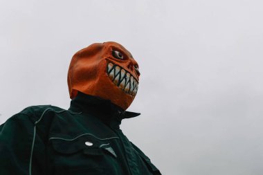 Gri sonbahar gökyüzünde kabak canavarı. Cadılar Bayramı tüyler ürpertici..