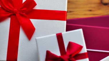 Hediye arka planı. Kırmızı kurdeleli beyaz kutular yakın plan. Festivaller için hediye kutuları hazırlıyorum. 4k görüntü