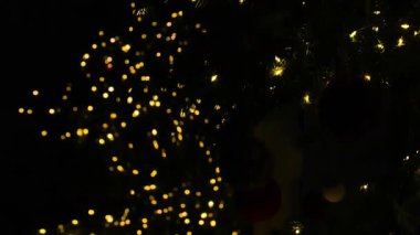 Bokeh çelenkleri karanlıkta parlar. Siyah arkaplanda parıldayan siyah dokular. Şenlikli yeni yıl ve Noel duvar kağıdı. 4k görüntü