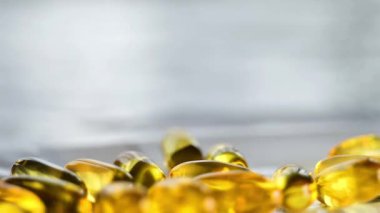 Omega yağ asitleri. Jelatin kapsüller masaya düşer. Sağlıklı yağ ve besin maddeleri. 4k görüntü