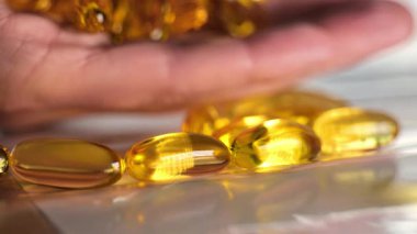 Omega üç kapsül kadın avuçlarında hafif arka planda. Sağlıklı yağlar ve kadınlar sağlıklıdır. Kadınlarda beslenme takviyeleri ve vitaminler. 4k görüntü