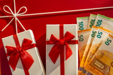 Avrupa Banknotları ile Hediye Kutusu. Kırmızı Arkaplanda Hediye ve Euro Para Birimi. Kırmızı Hediye Kutularının Üzerinde Euro Banknotları. Kırmızı Paketli Hediyenin Yanında Nakit Hediye. Hediye almanın maliyeti. 