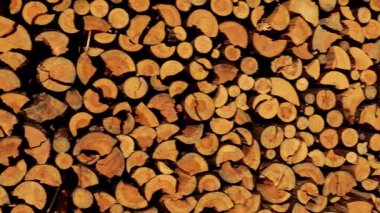 Yakacak odun arka planı. Katı yakıt. Kesilmiş odun yığını. Isınma mevsimi için odun hazırlama ve depolama. Doğal ısı kaynağı ve evin ısıtması. 4k görüntü