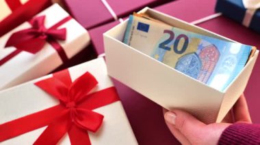 Para hediyesi. Hediye kutusunda Euro parası. Eller kaseyle kutuyu açar. Hediye olarak para ver ve al. 4k görüntü