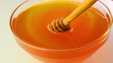 Çiftlik doğal balı. Bal çubuğu altın bala batıyor. Cam bir kaseye yakın. Doğal sağlıklı iyileştirme tatlısı.. 