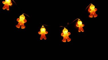 Noel duvar kâğıdı. Zencefilli çörekler siyah arka planda kürek çekiyor. Sıcak kış tatili atmosferi. 4k görüntü