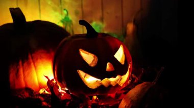 Karanlıkta yeşil dumanlı korkunç balkabağı Jack. Sonbahar bayramı için korkunç bir dekorasyon. 4k görüntü