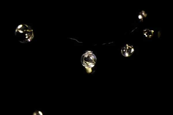 Outdoor wedding and party light, neon bulb on the black background