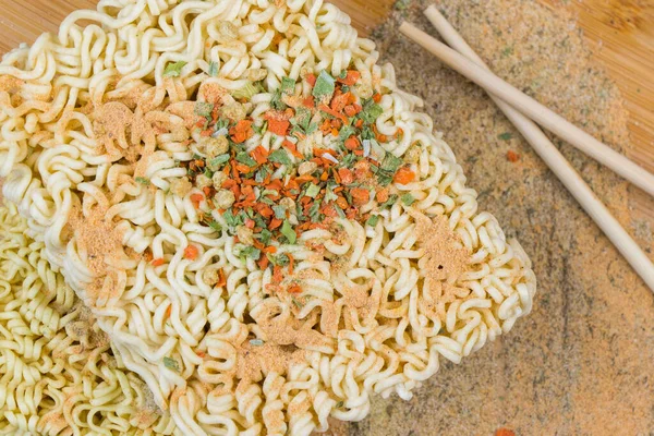 Fast food, chinese raw noodles with spices on the wooden background