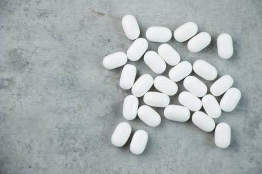 Gri arka planda beyaz haplar ve uyuşturucular