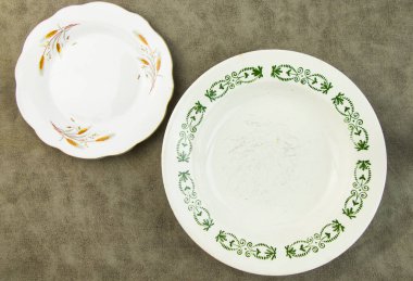 Boş sofra takımı ve bulaşık takımı ayarları ve gri arka planda servis, tabak, kase ve klasik kaşık