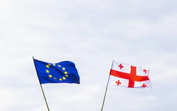 European union and Georgian flag on the sky background