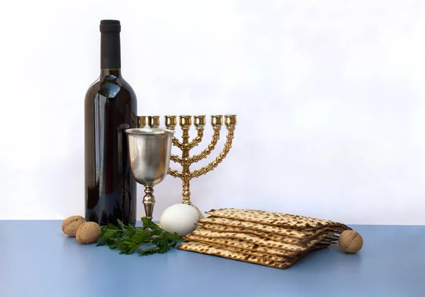 マッツォ ワイン Menorah 文字のためのスペースとライトの背景に青色のテーブルの上に合格お祝いのためのナッツ — ストック写真
