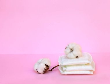 Çiçekli tek kullanımlık ürünler pembe arka planda pamuk ve metin için yer var.