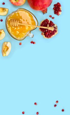 Cam kasede bal, kırmızı elmalar, yakut yaprakları, mavi arka planda ahşap bal kaplaması.