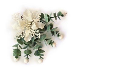 Noel süsü. Beyaz açı noktalı çiçek, beyaz arka planda beyaz böğürtlen otu ve metin için yer. Üst manzara, düz yatış. Geleneksel ökse otu Noel demeti