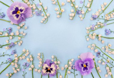 Beyaz çiçekli vadi zambağı (Convallaria majalis, Mayıs çanları, mayıs zambağı), mavi çiçekli unutma beni-nonoşlar, mavi kağıtta yer alan menekşe nonoşu. Üst manzara, düz uzanma