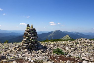 Zen taşı yığını, yazın dağlarda üst üste yığılmış doğal kayalar. Uyum ve denge kavramı. Tonsal perspektif
