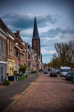 Hollanda 'nın arka planında Noorderhaven Harlingen, Sint-Michalkerk limanındaki evlerin tarihi cepheleri görülebilir.