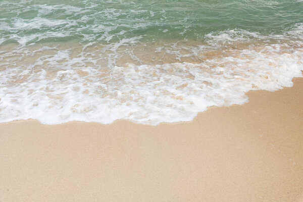 Sea waves bubbles on the sandy beach