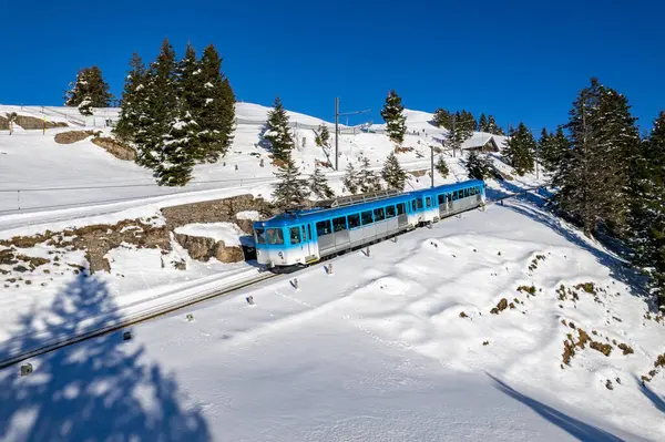 Mavi Rigibahn treni kış mevsiminde Goldau 'ya giderken Rigi Dağı' ndan inerken görüldü..