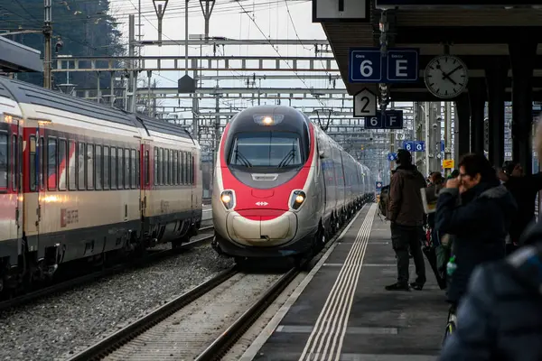 Birçok insan şu anda yaklaşmakta olan bir trene binmek için bekliyor.