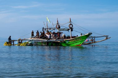 Laiya Sahili, Batangas, Filipinler - 16 Ağustos 2024: Balıkçılar sabahın erken saatlerinde kıyıya geri dönüyorlar. Kıyı köylerindeki insanlar geleneksel yollarla yaşamaya devam ediyorlar.