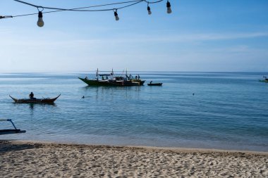 Laiya Sahili, Batangas, Filipinler - 16 Ağustos 2024: Balıkçılar sabahın erken saatlerinde kıyıya geri dönüyorlar. Kıyı köylerindeki insanlar geleneksel yollarla yaşamaya devam ediyorlar.