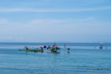 Laiya Sahili, Batangas, Filipinler - 16 Ağustos 2024: Balıkçılar sabahın erken saatlerinde kıyıya geri dönüyorlar. Kıyı köylerindeki insanlar geleneksel yollarla yaşamaya devam ediyorlar.