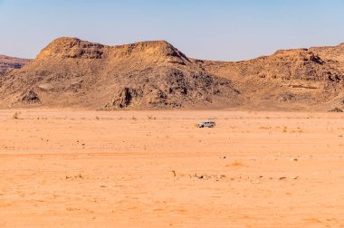 Yazın Ürdün 'ün Wadi Rum kentindeki çöl manzarasında yalnız bir aracın görüntüsü