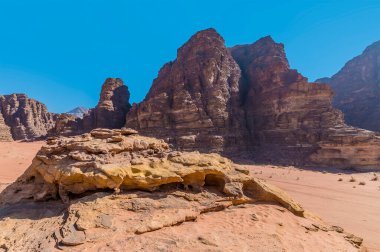 Yaz mevsiminde Ürdün 'ün Wadi Rum kentindeki engin çöl manzarasının kumtaşı çıkıntıları.