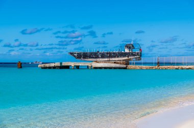 A view along the shore towards a jetty on the island of Grand Turk on a bright sunny morning
