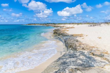 A view of a rocky shoreline and breaking surf on the island of Grand Turk on a bright sunny morning
