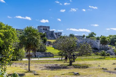 A view across temple ruins at the Mayan settlement of Tulum, Mexico on a sunny day