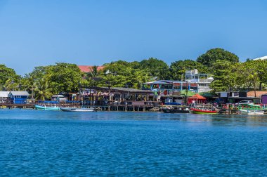 Güneşli bir günde Roatan Adası 'ndaki West Bay' deki sahil binalarının manzarası.