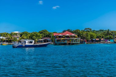 Güneşli bir günde Roatan Adası 'ndaki Batı Körfezi' nde bir teknenin manzarası.