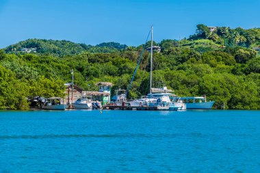 Güneşli bir günde Roatan Adası 'ndaki Batı Körfezi' ne demirlemiş teknelerin görüntüsü