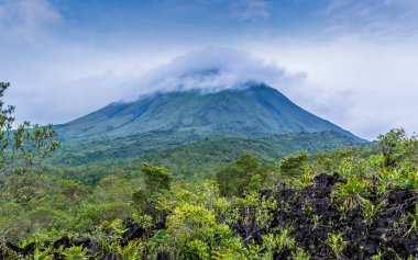 Kurak mevsimde Kosta Rika 'da yapılan zirvede Arenal yanardağına doğru uzanan lav tarlaları bulutlarla kaplı.