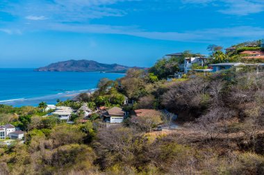 Kurak mevsimde Tamarindo tatil köyünün üzerinden Kosta Rika 'daki Tamarindo nehrine doğru bir manzara