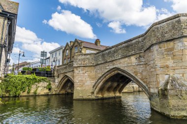 Yazın Cambridgeshire, St Ives 'deki Büyük Ouse Nehri üzerindeki ortaçağ yaya köprüsüne bakan bir manzara