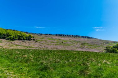 Yazın İngiltere 'nin Peak District bölgesindeki Stanage Edge' in en yüksek yamacına doğru bir bakış açısı