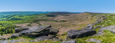 İngiltere 'nin Peak District bölgesindeki Stanage Edge yamacında, yamacın yay boyunca bir manzara.