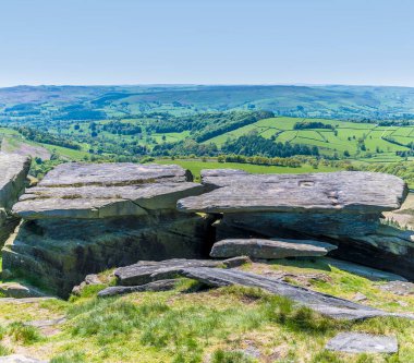 İngiltere 'nin Peak District bölgesindeki Stanage Edge yamaçlarındaki değirmen taşı masasının tepesi.