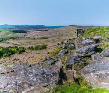 İngiltere 'nin Peak District bölgesinde yaz mevsiminde Stanage Edge yamaçları boyunca uzanan bir manzara