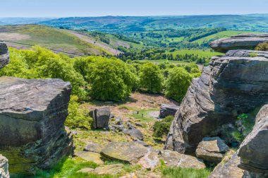 İngiltere 'nin Peak District bölgesindeki Stanage Edge yamaçlarındaki değirmen taşı kaplamalarındaki boşluğa bakan bir manzara