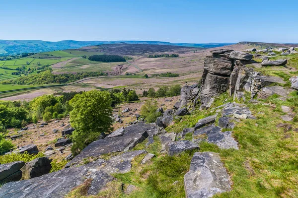 stock image A view past millstone outcrops from the highest point on the top of the Stanage Edge escarpment in the Peak District, UK in summertime