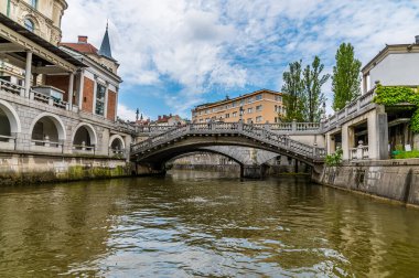Slovenya 'nın Ljubljanica Nehri' nin Ljubljana kentindeki Üçlü Köprü 'nün altından geçen manzarası