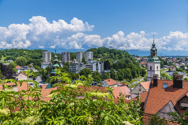 A view across the rooftops towards the old and new parts of the town of Skofja Loka, Slovenia in summertime