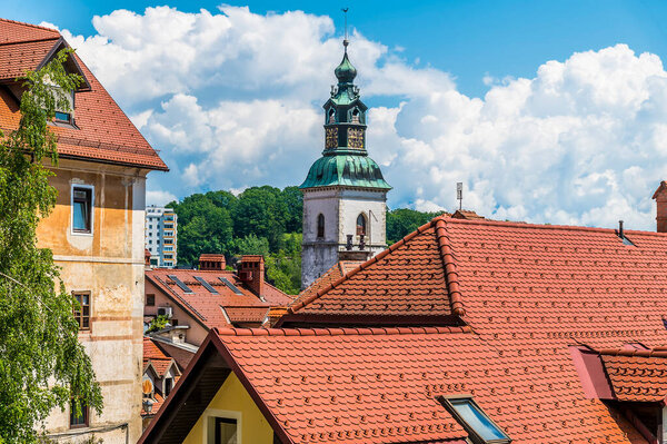 A view over the rooftops towards the cathedral tower in the old town of Skofja Loka, Slovenia in summertime